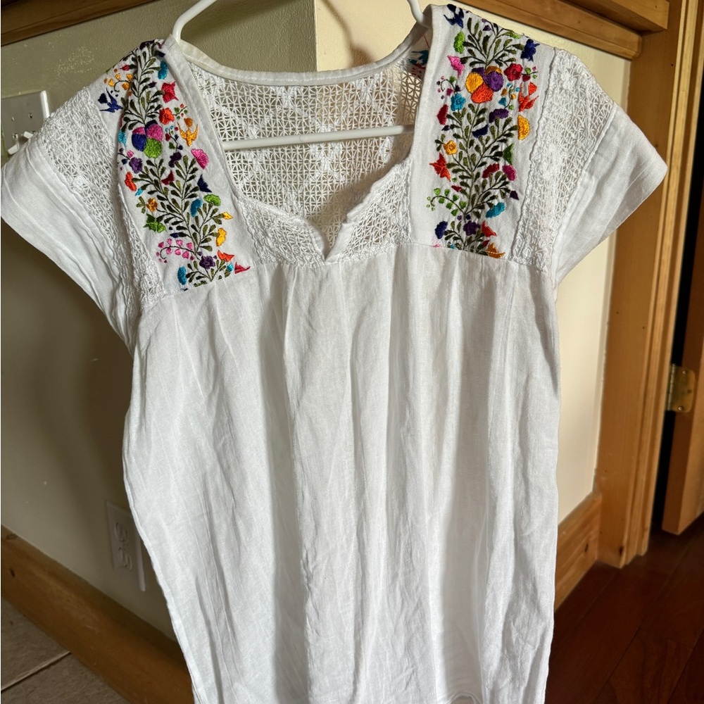 Embroidered white linen shirt with colorful accents of flowers. Size small.